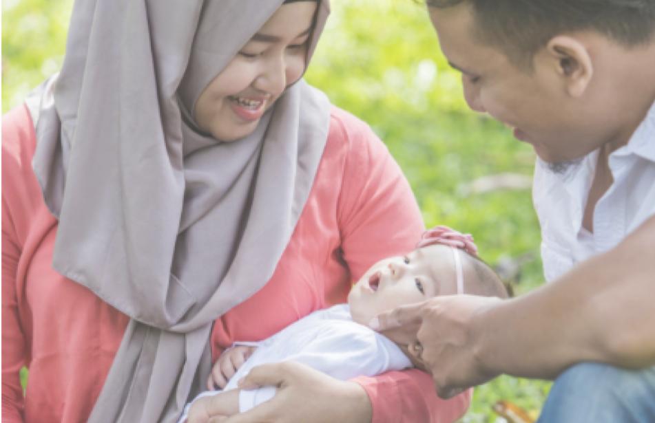 parents holding baby on grass