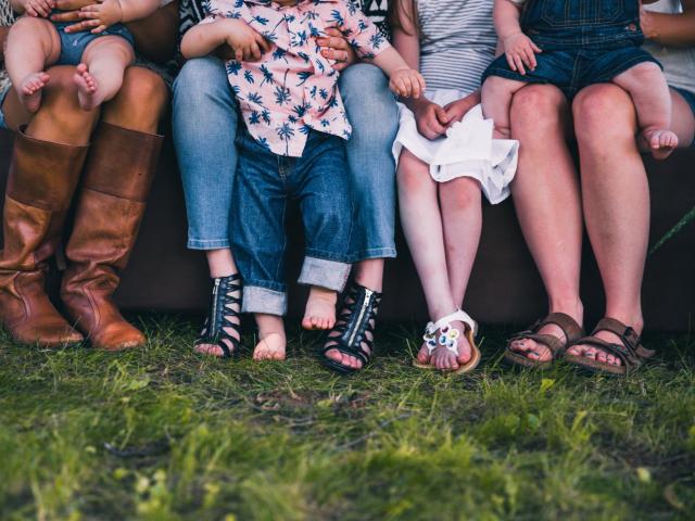 Shot of legs showing a group of mothers and children in a row