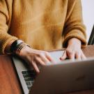 Person typing on a laptop computer.