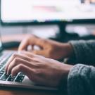 Person typing on a laptop computer.